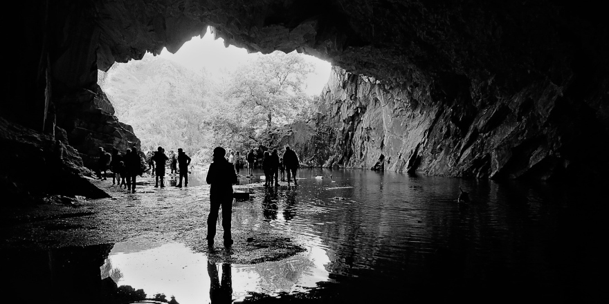 Black and white image of people in cave