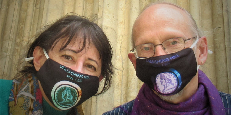 Woman with brown hair and man with grey hair pose with facemasks on.