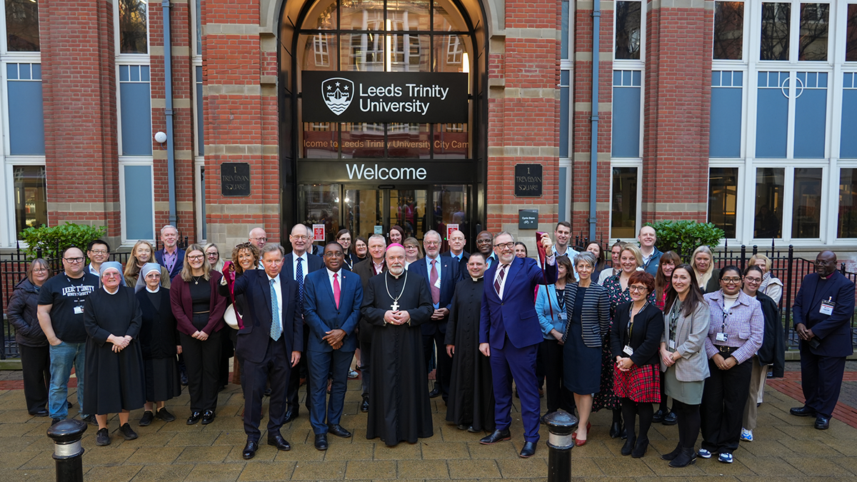 A group of guests with the Bishop of Leeds in front of the Leeds Trinity University City Campus.