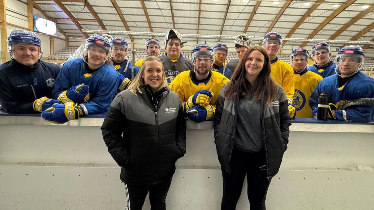 Two members of University staff pose for a picture with the Leeds Knights ice hockey team