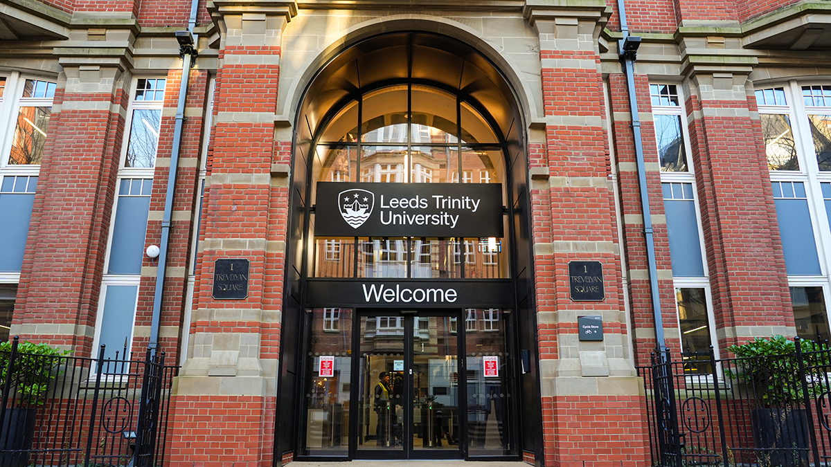 The entrance to the Leeds Trinity University City Campus, a black door on which are printed, in white, the words Leeds Trinity University, welcome.